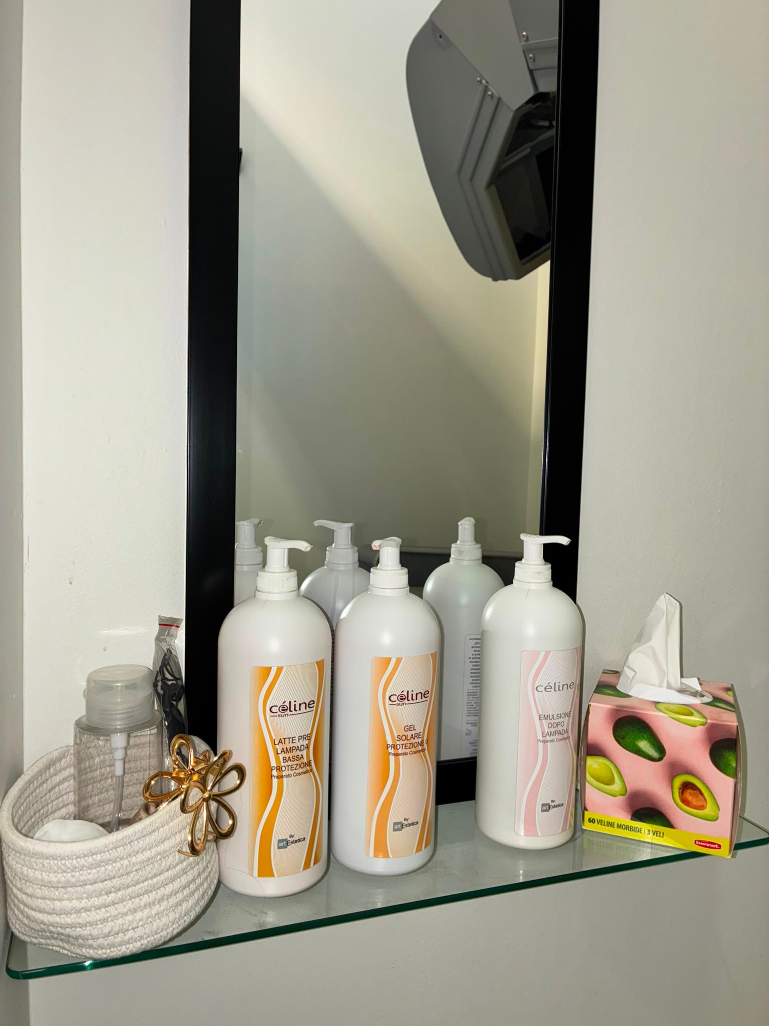 La mensola in cabina con le creme pre e dopo lampada Céline